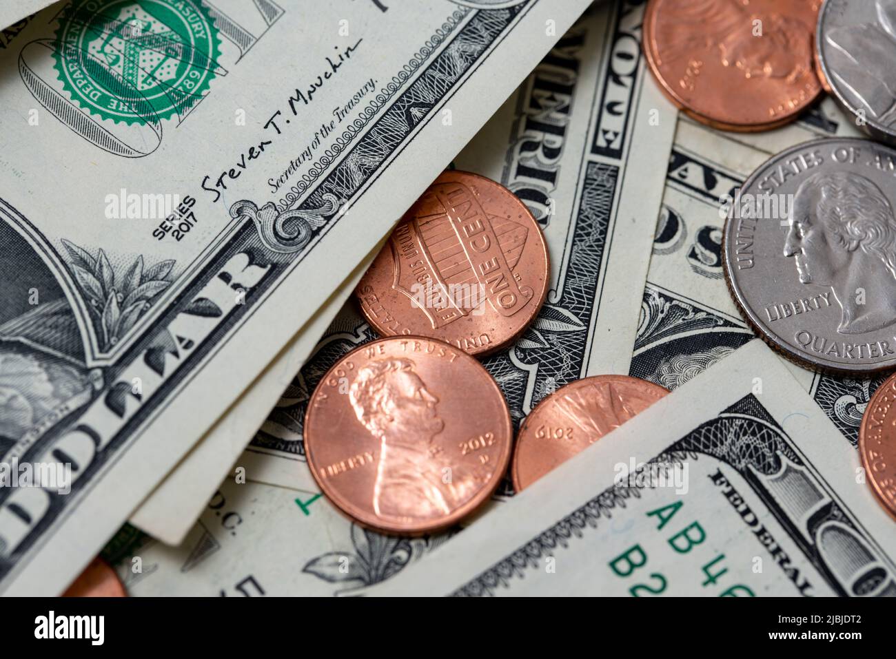 Pennies zwischen Dollarscheinen. US-Dollar-Papiergeld und -Münzen. Stockfoto