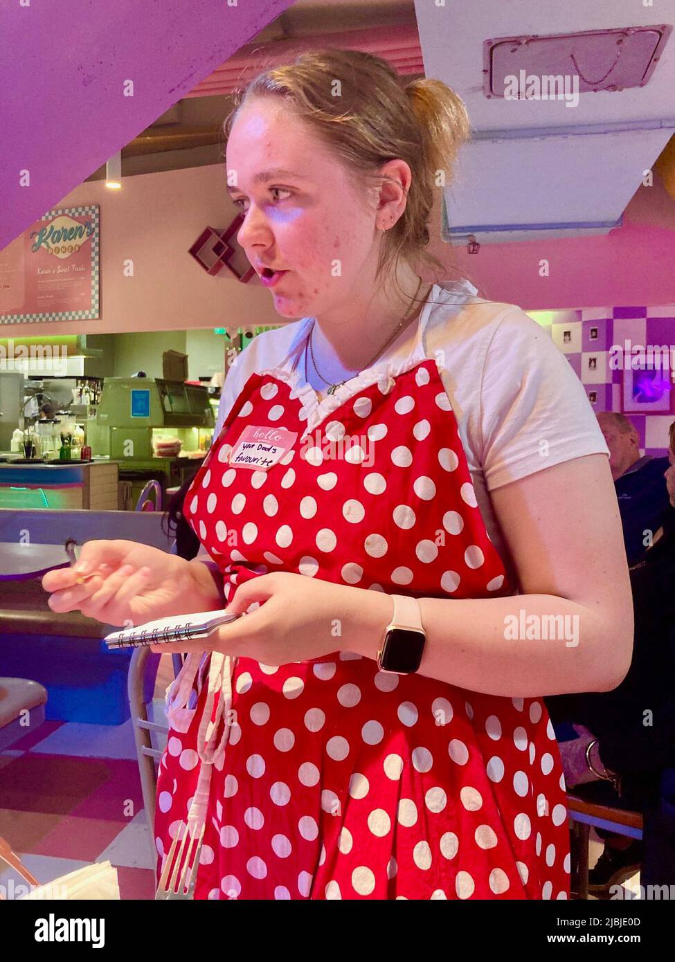 Sydney, Australien. 25.. Mai 2022. Eine leicht verärgerte Kellnerin in rot-weißer Schürze nimmt die Bestellung bei Karen's Diner an. Restaurants sind in der Regel stolz auf ihren guten Service. Nicht so im australischen Karen's Diner: Hier werden die Gäste mobbt und extra schlecht bedient. Das kuriose Konzept wird so gut angenommen, dass die Kette nun weltweit expandiert. (To dpa 'unhöfliche Kellner als Erfolgsrezept: Karen's Diner erobert Australien') Quelle: Carola Frentzen/dpa/Alamy Live News Stockfoto