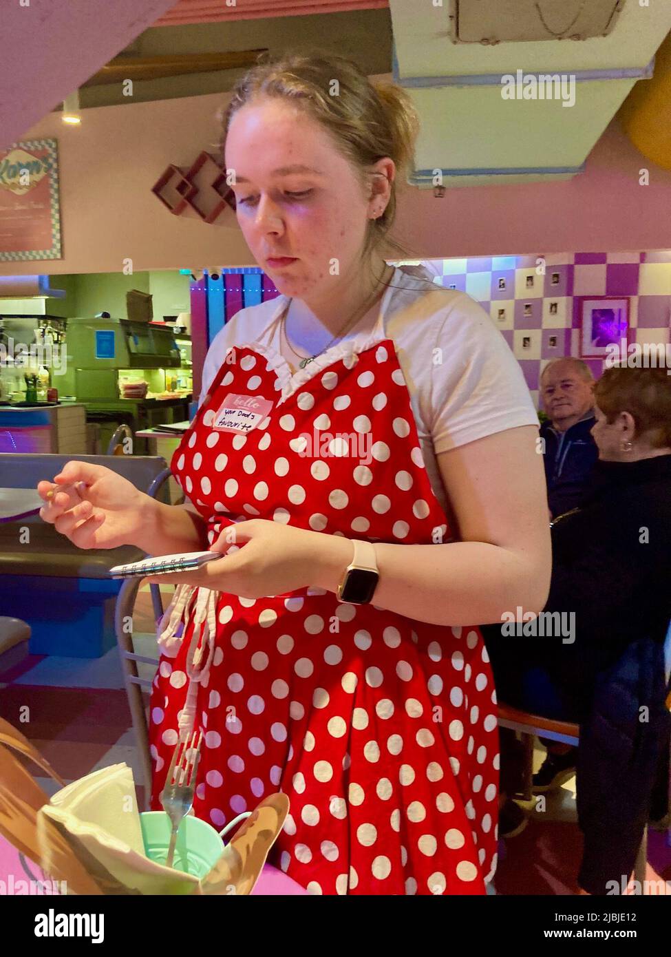 Sydney, Australien. 25.. Mai 2022. Eine leicht verärgerte Kellnerin in rot-weißer Schürze nimmt die Bestellung bei Karen's Diner an. Restaurants sind in der Regel stolz auf ihren guten Service. Nicht so im australischen Karen's Diner: Hier werden die Gäste mobbt und extra schlecht bedient. Das kuriose Konzept wird so gut angenommen, dass die Kette nun weltweit expandiert. (To dpa 'unhöfliche Kellner als Erfolgsrezept: Karen's Diner erobert Australien') Quelle: Carola Frentzen/dpa/Alamy Live News Stockfoto