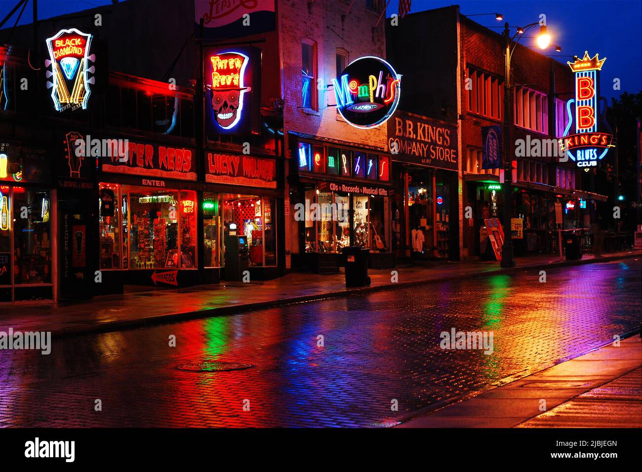Die bunten Neonlichter der Clubs, Tavernen und Bars auf der Beale Street in Memphis, Tennessee, spiegeln sich in der regnerischen Straße wider Stockfoto