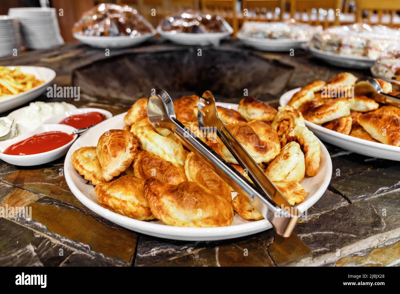 Samsa, Sandwiches und andere Snacks und Backwaren stehen am Veranstaltungstag im Buffetbereich Stockfoto