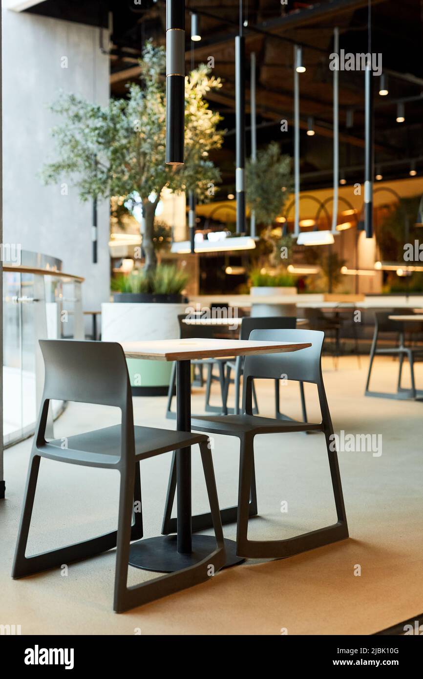 Vertikales Hintergrundbild von Tisch und Stühlen im Loft-Stil Food Court Interieur Stockfoto