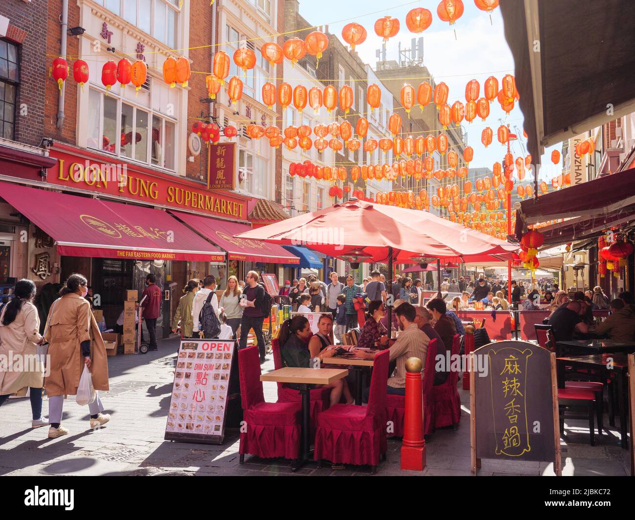 Menschen essen im Freien in einem belebten chinesischen Restaurant in der Gerrard Street im Chinatown-Viertel im Zentrum von London, Großbritannien Stockfoto