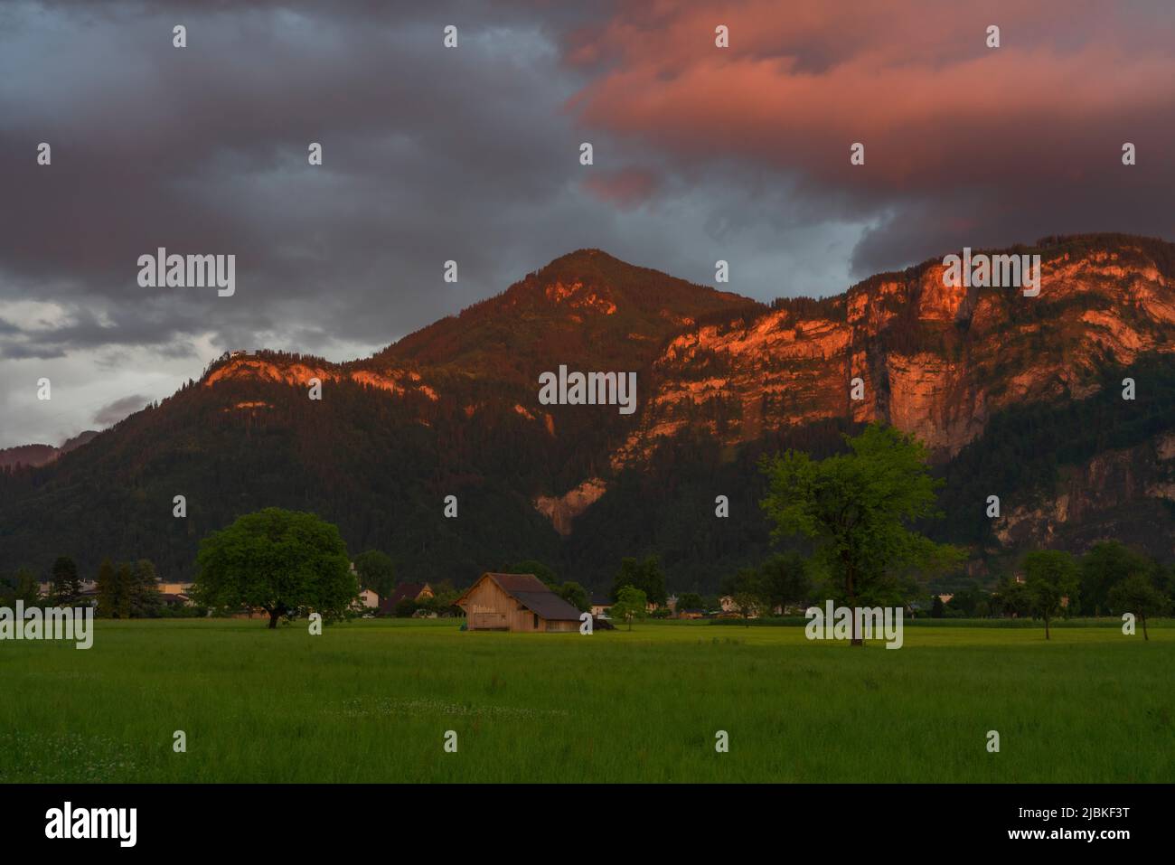 Dämmerung nach dem Sonnenuntergang in Dornbirn, Vorarlberg, Österreich. Tolle Stimmung mit interessanteren graublau Wolken, grünen Wiesen und Haus Stockfoto