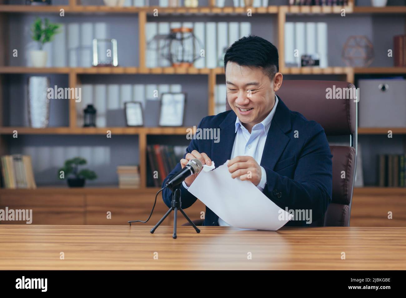 Mann zerreißt Papier im Aufnahmestudio, Asian nimmt ASMR-Sound auf Stockfoto