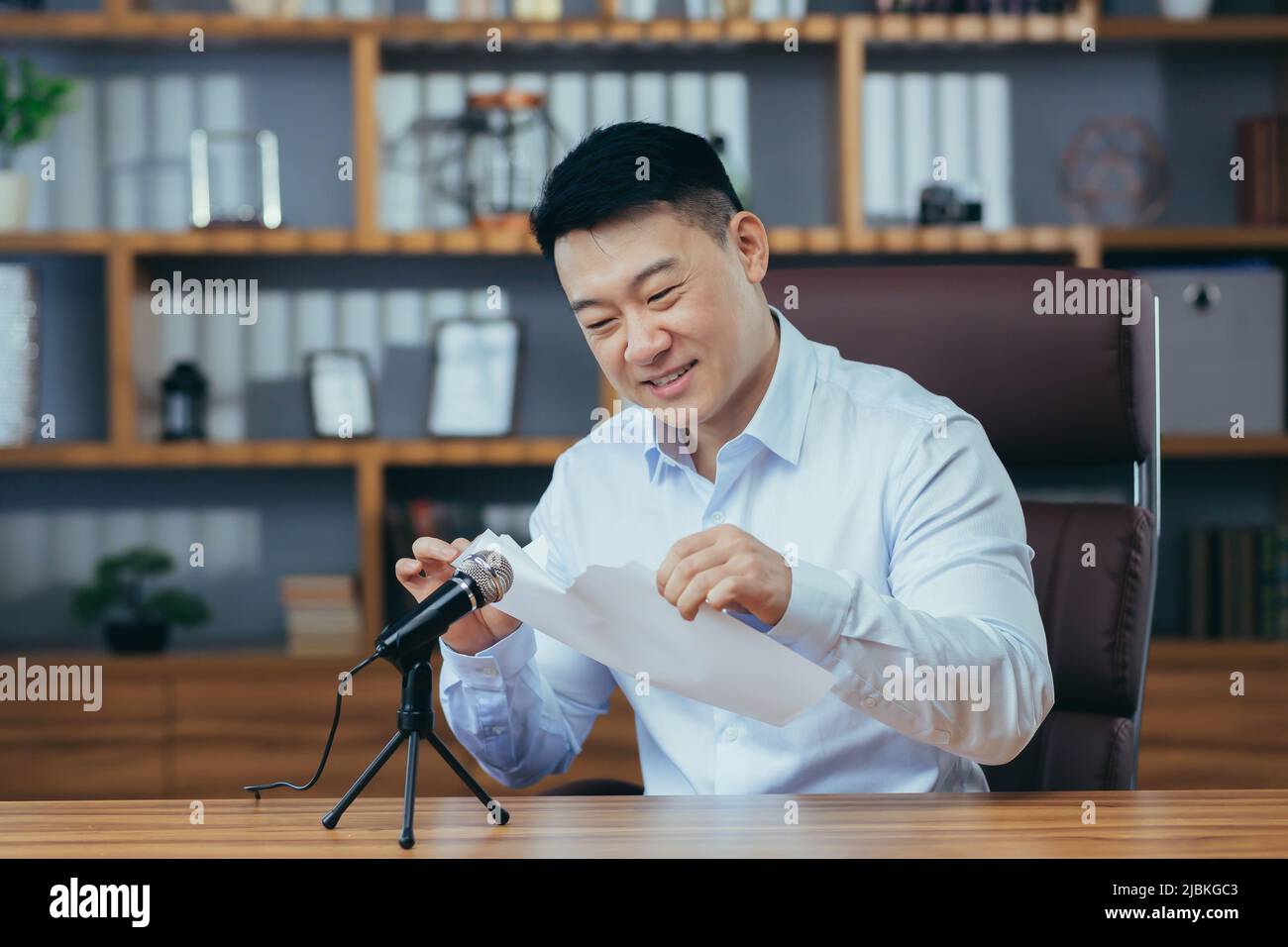 Mann zerreißt Papier im Aufnahmestudio, Asian nimmt ASMR-Sound auf Stockfoto