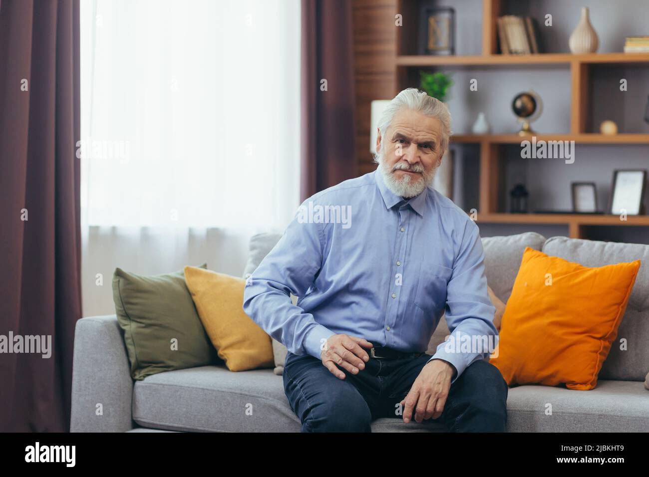 Ernst für nachdenklichen Großvater Mann sitzt auf dem Sofa zu Hause Stockfoto