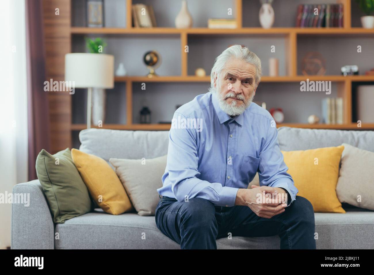 Ernst für nachdenklichen Großvater Mann sitzt auf dem Sofa zu Hause Stockfoto