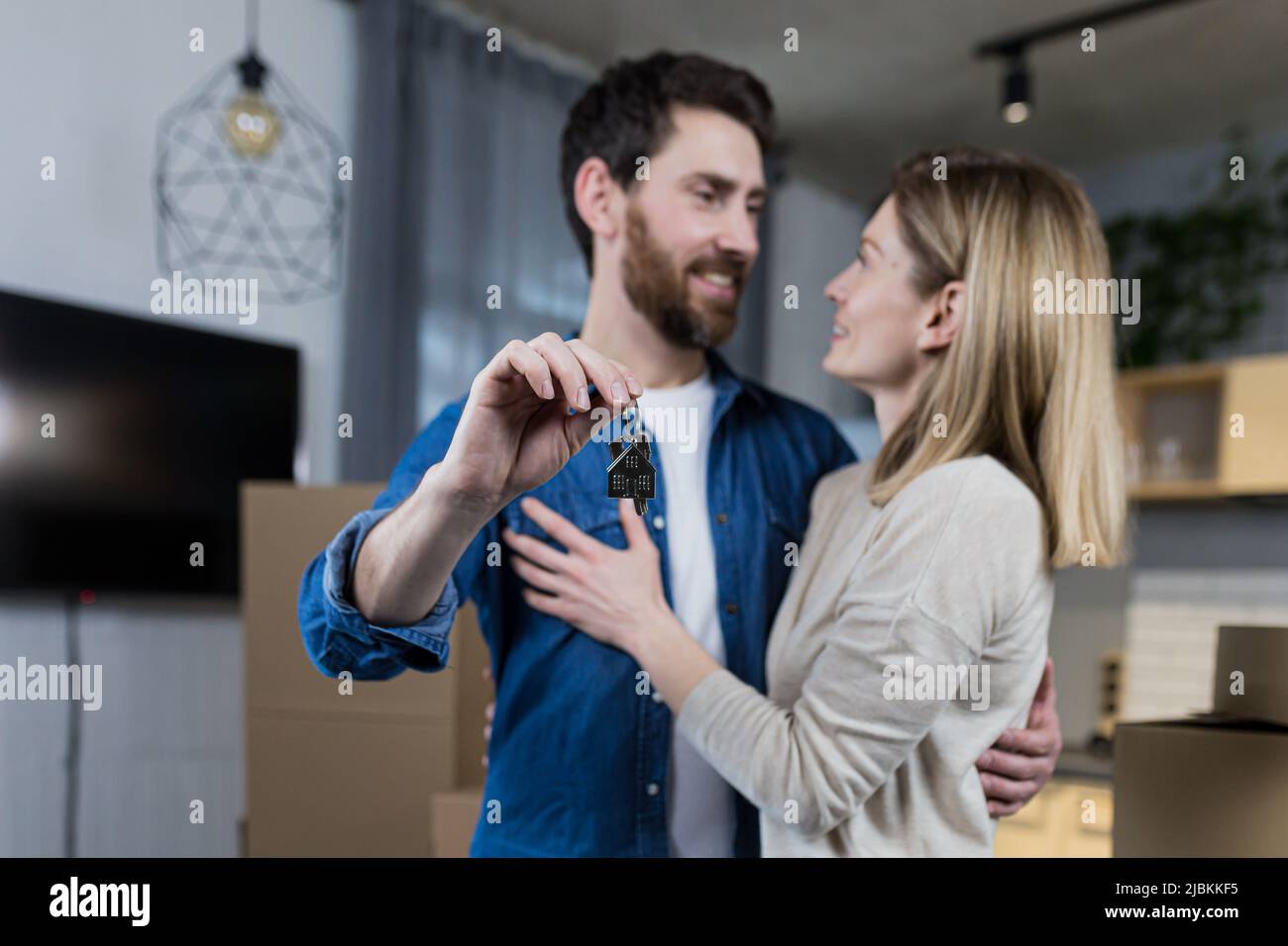 Ausgewählte Fokus, verheiratetes Paar Mann und Frau glücklich zusammen, umarmt, die Schlüssel zu ihrer neuen Wohnung, Hausarmung, Nahaufnahme Stockfoto
