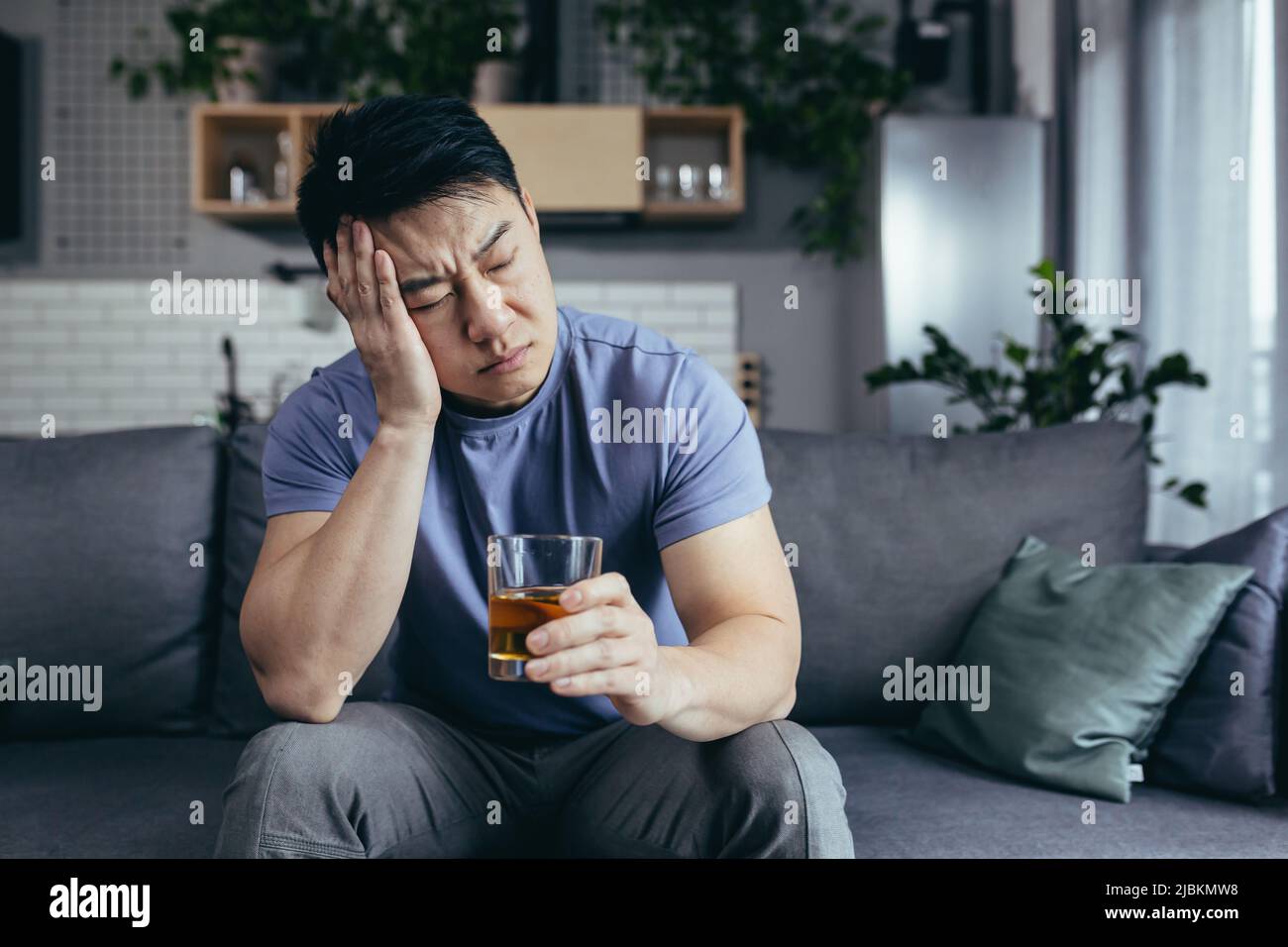 Asiatischer Mann zu Hause allein, depressiv, starker Alkoholkonsum, alleinstehender Mann Stockfoto