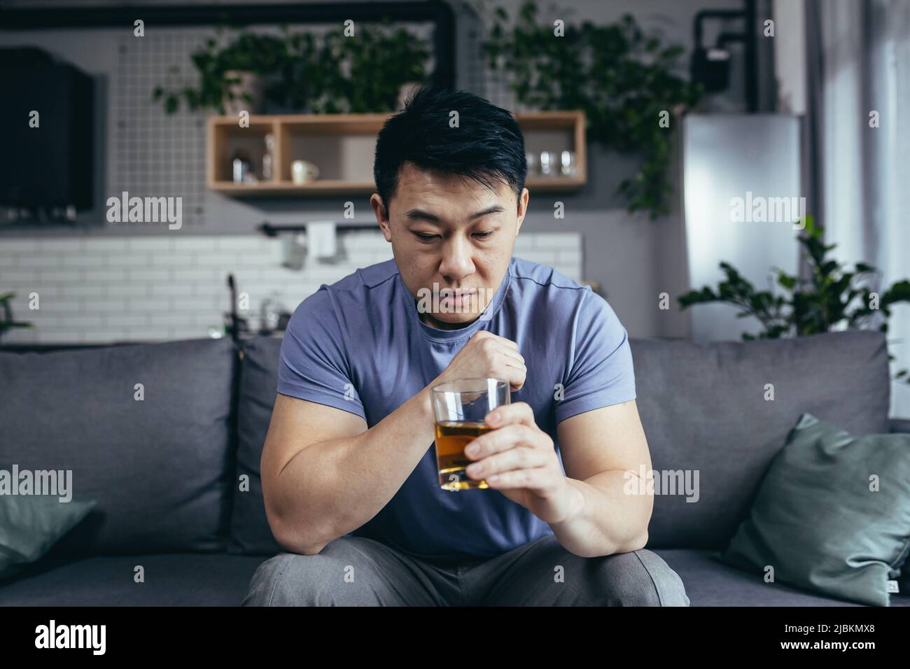 Asiatischer Mann zu Hause allein, depressiv, starker Alkoholkonsum, alleinstehender Mann Stockfoto