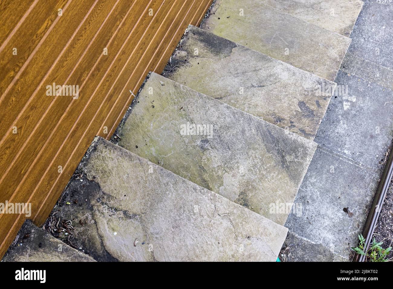 Indische Sandsteinstufen verfärbt mit Algen, die gereinigt werden müssen, Wales, Großbritannien Stockfoto