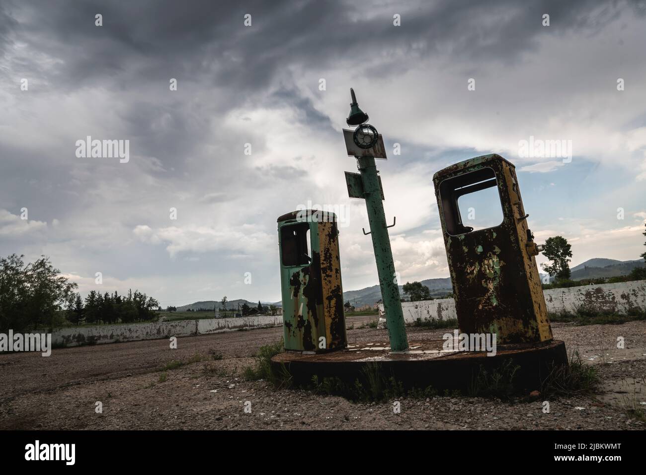 Die zerstörte rostige Tankstelle vor dem Hintergrund des düster strukturierten Himmel-Copyspace, verlassen den beängstigenden Platz aus Horrorfilmen. Stockfoto