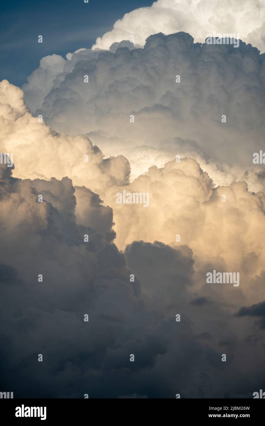 Erstaunliche Kumuluswolken vor einem schweren Gewitter in den österreichischen Bergen bei Sonnenuntergang. Stockfoto