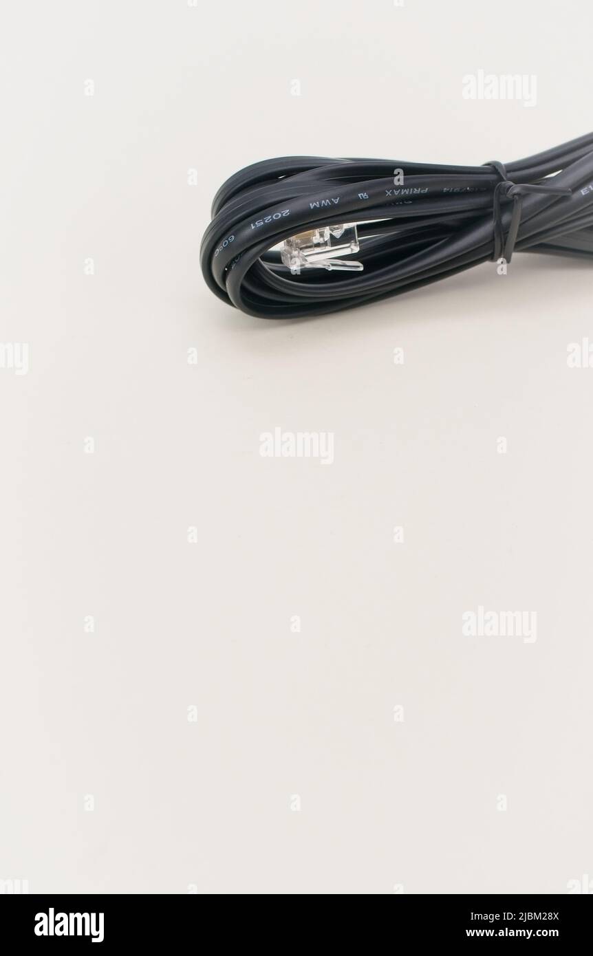 Isoliertes Datenkabel mit RJ11-Telefonmodemanschluss auf einem weichen weißen Schreibtisch Stockfoto