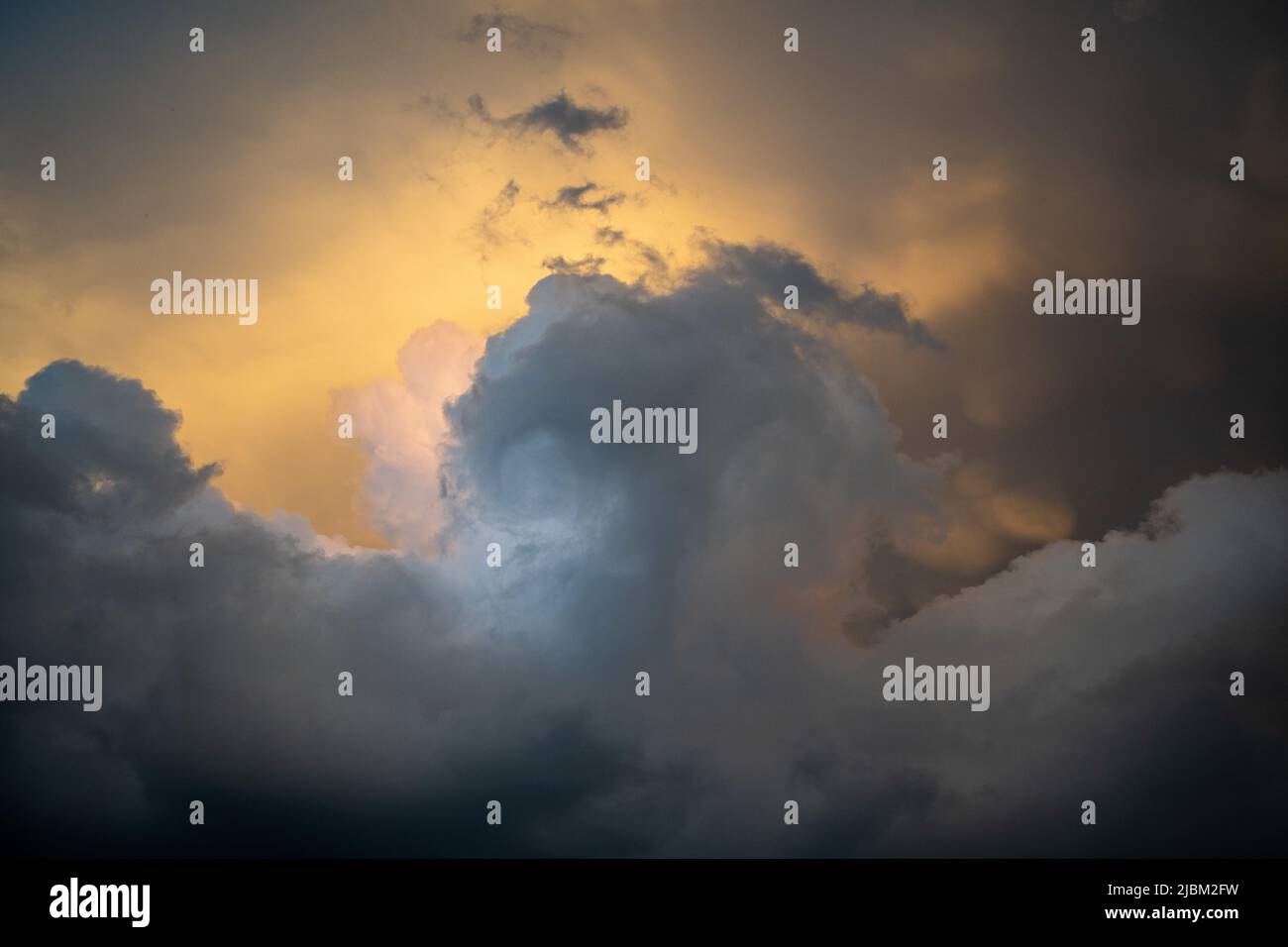 Erstaunliche Kumuluswolken vor einem schweren Gewitter in den österreichischen Bergen bei Sonnenuntergang. Stockfoto