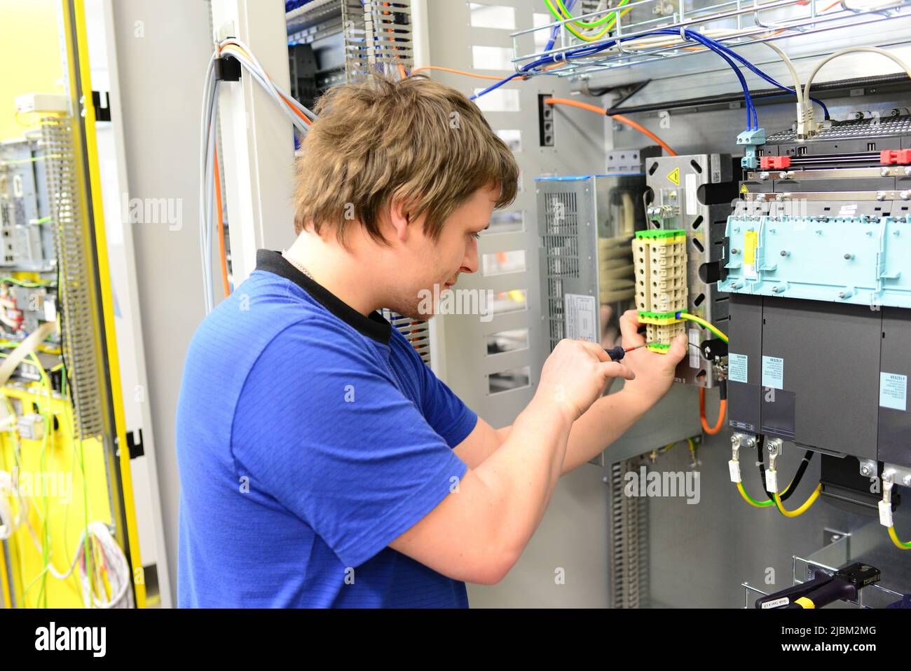 Junge Auszubildende montiert Komponenten und Kabel in einer Fabrik in Ein Schaltschrank - Arbeitswelt mit Zukunft Stockfoto