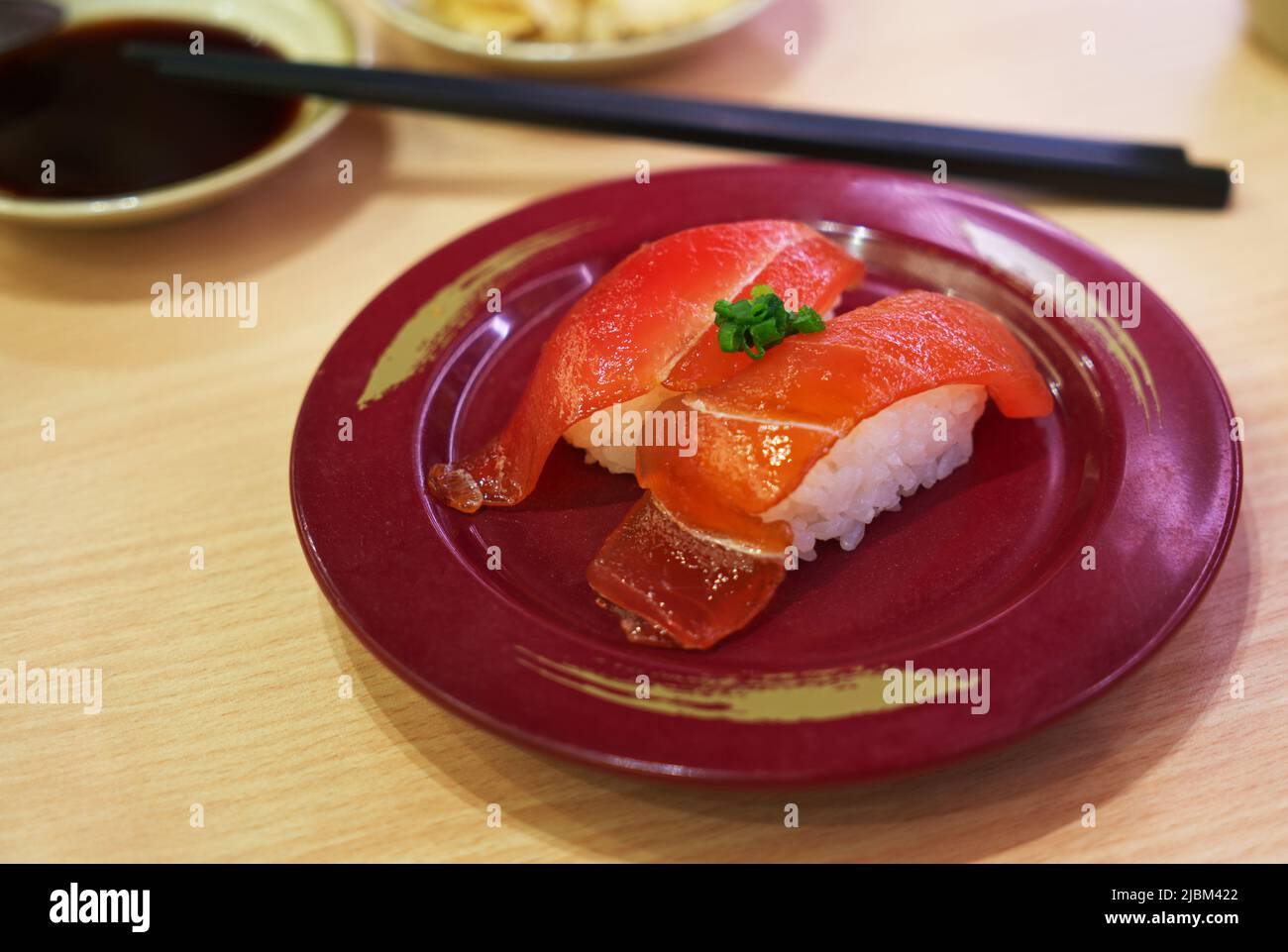 Marinierter Thunfisch mit Sojasauce Sushi oder mariniertes Maguro mit Shoyu Sushi, Sushi auf einem runden Teller auf dem Tisch im Restaurant. Nahaufnahme von Jap Stockfoto