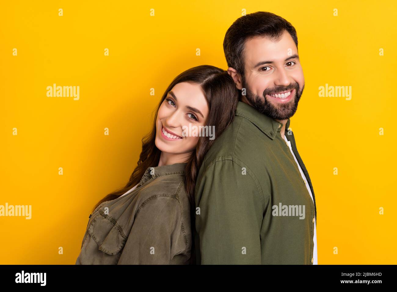 Profil-Seitenfoto von Rücken zu Rücken Menschen Geschwister verbringen freie Wochenend-Zeit zusammen isoliert auf gelbem Hintergrund Stockfoto