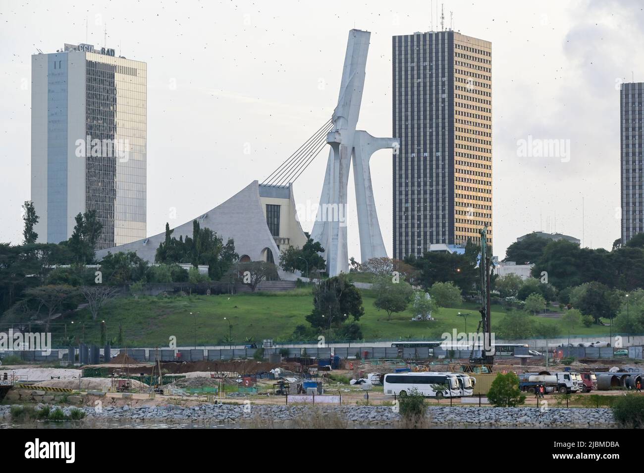 ELFENBEINKÜSTE, Abidjan, Stadtzentrum Plateau, große Gebäude und Kathedrale St. Paul erbaut 1985 von dem Architekten Aldo Spirito, vor dem chinesischen Arbeitslager der Baufirma / ELFENBEINKUESTE, Abidjan, Stadtzentrum Plateau, Hochhäuser und Kathedrale „St. Paul“ baut 1985 von Architekt Aldo Spirito Stockfoto