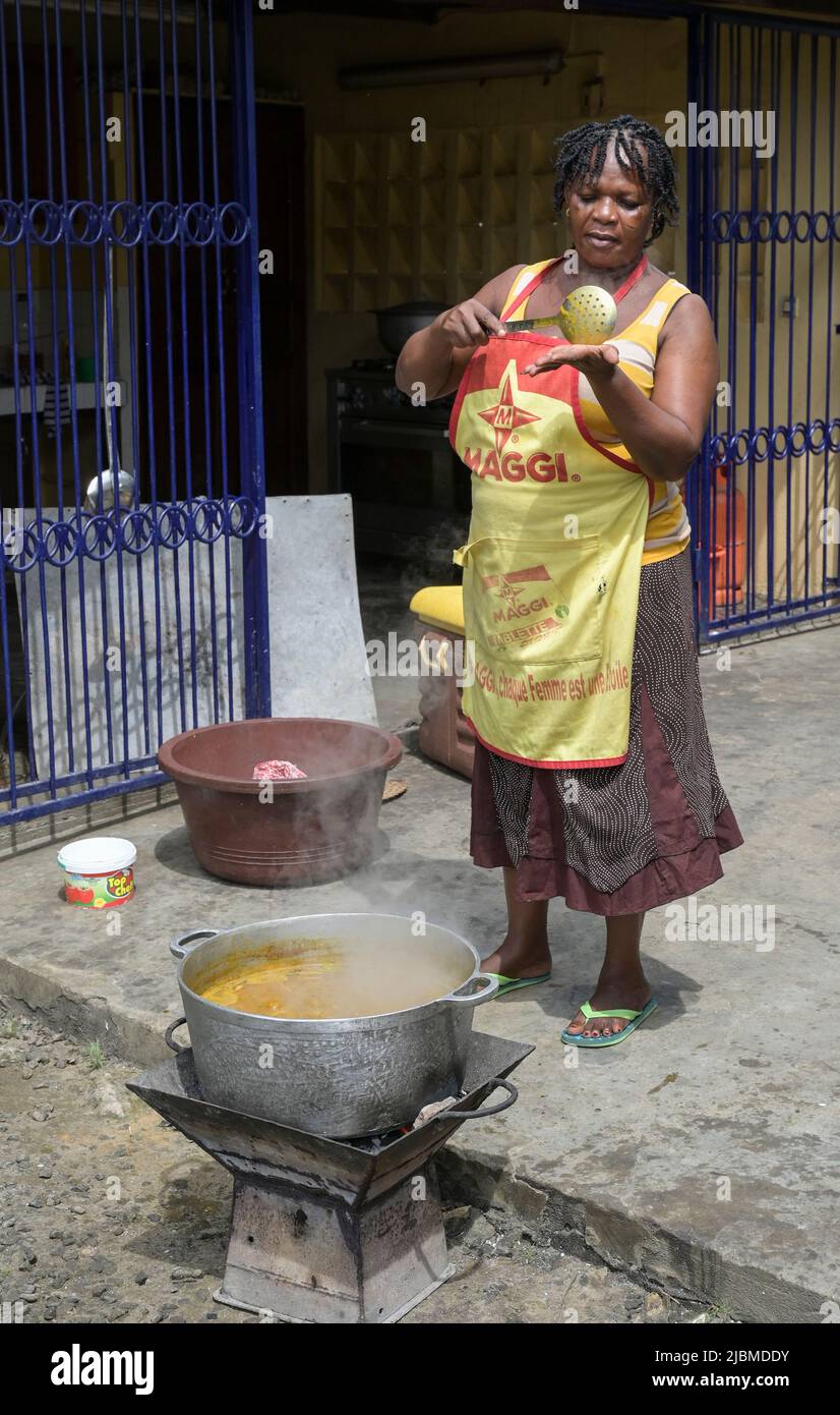 ELFENBEINKÜSTE, Abidjan, Schulküche, Köchin mit Küchenschürze Maggi Werbung der schweizer Firma Nestle / ELFENBEINKUESTE, Abidjan, Stadtteil Koumassi-Remblais, Schulküche, Köchin in Schürze mit Maggi Werbung des Schweizer Konzern Nestle Stockfoto