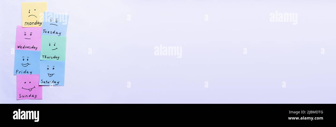 Draufsicht auf mehrfarbige Karten mit verschiedenen Emoji- und Tagesnamen auf pastellviolettem Hintergrund, Banner Stockfoto