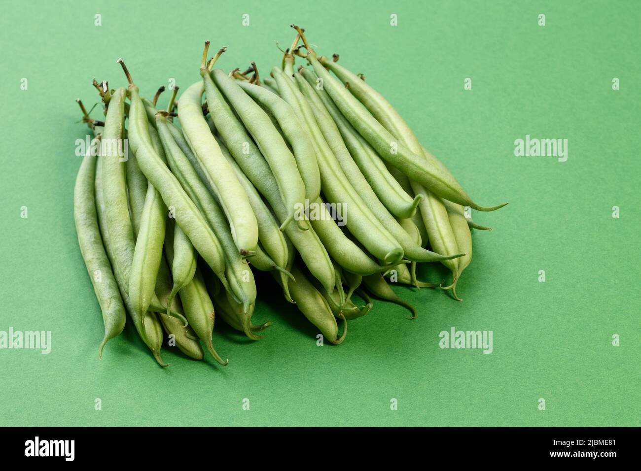 Ein Stapel grüner französischer Bohnen auf grünem Hintergrund Stockfoto