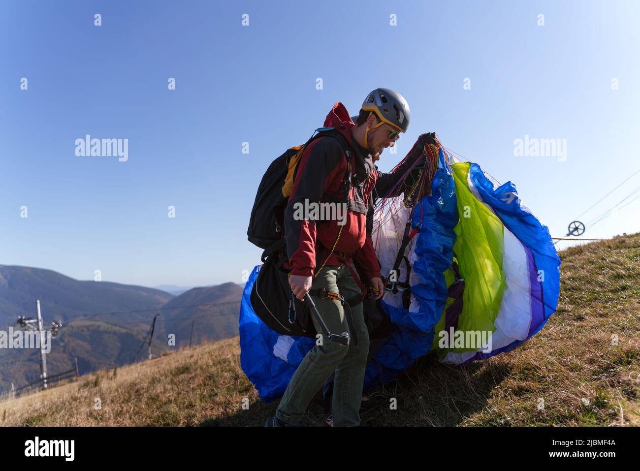 Gleitschirme bereiten sich auf den Flug in den Bergen vor. Extreme sportliche Aktivitäten. Stockfoto