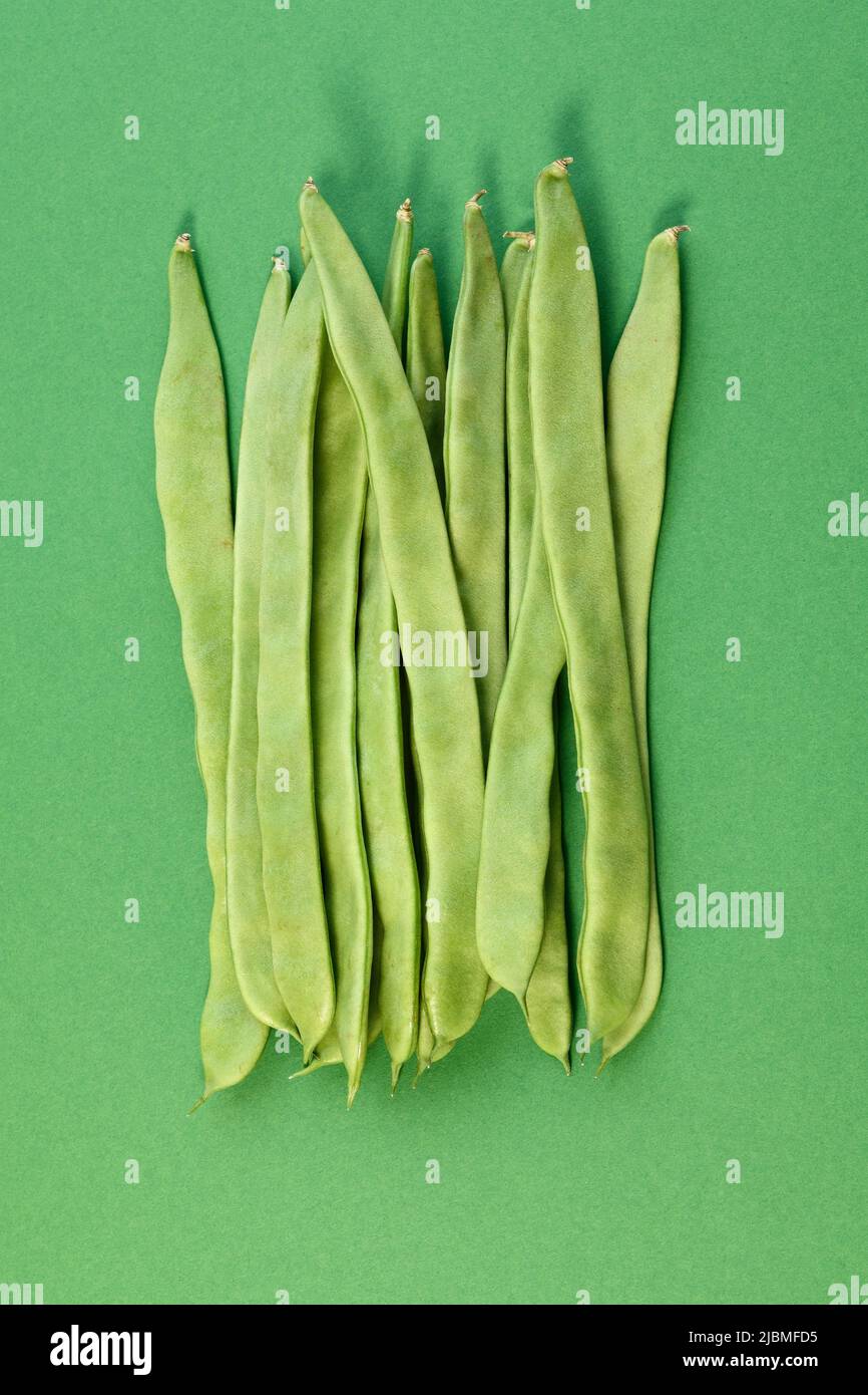 Ein Haufen von Läuferbohnen auf grünem Hintergrund Stockfoto