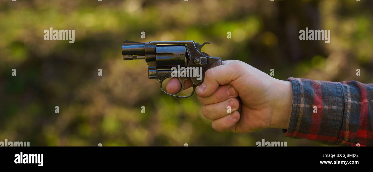 Nicht erkennbarer Mann mit Revolver, der auf den Schießstand im Freien zielt. Stockfoto