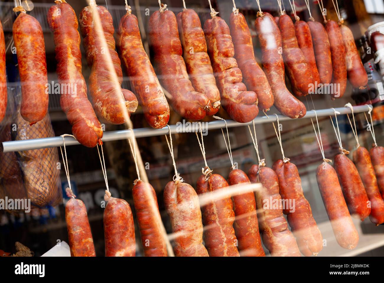 Trocken gehärtete traditionelle spanische Wurst hängen in einem Geschäft Stockfoto