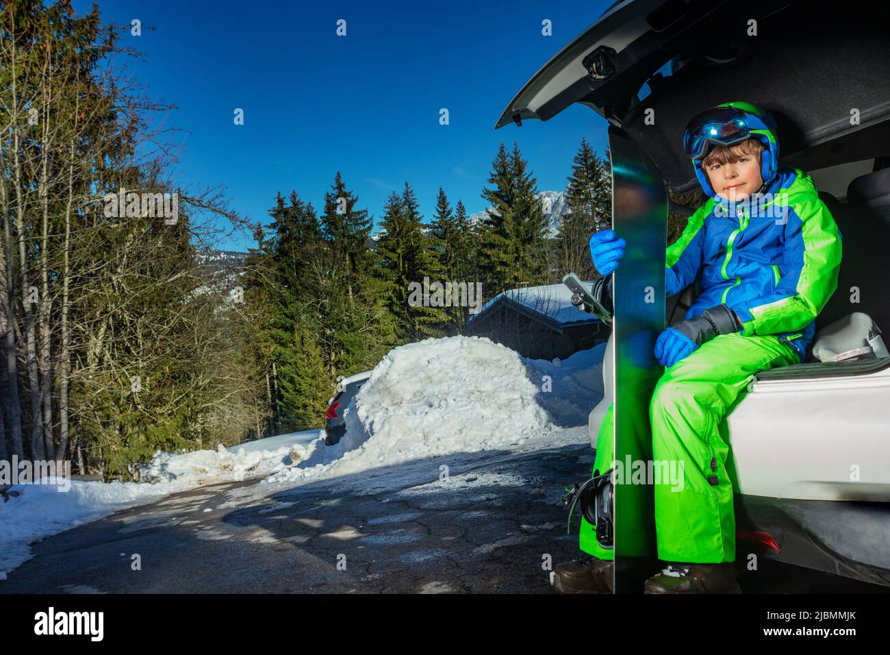 Close Portrait eines Jungen mit Snowboard im Kofferraum lächelnd Stockfoto