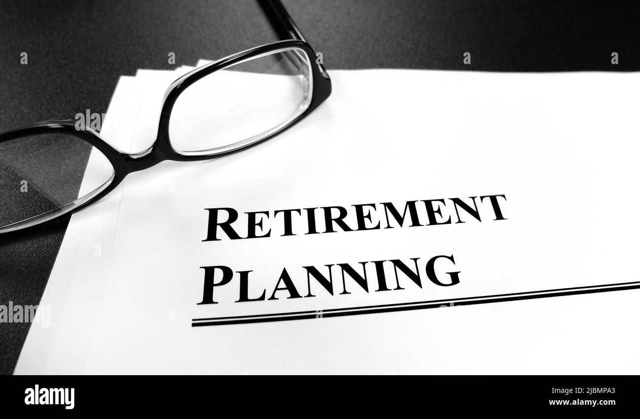 Unterlagen zur Altersvorsorge auf dem Schreibtisch mit Brille für den Plan zur Pensionierung Stockfoto