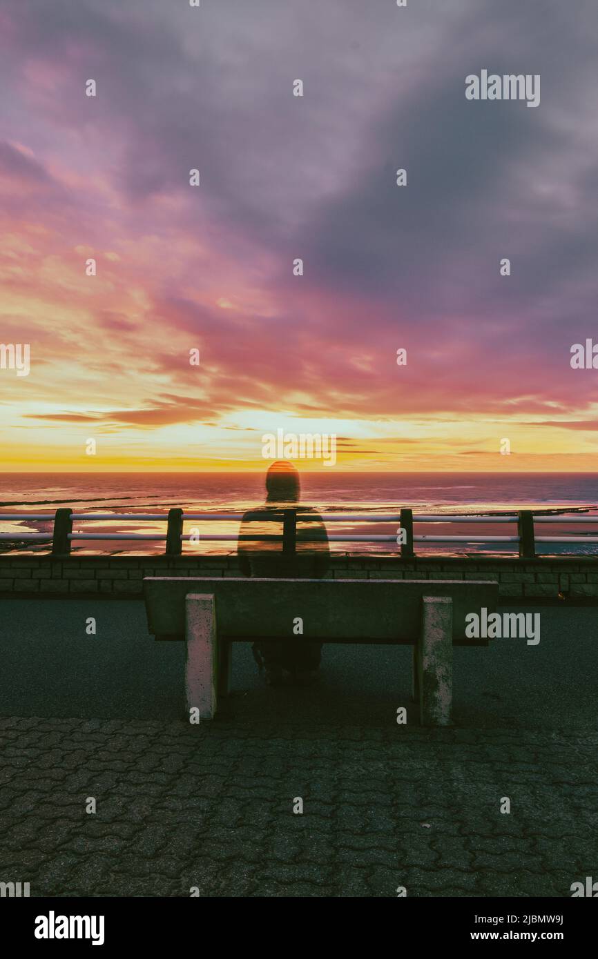 Schatten eines Mannes auf einer Bank bei Sonnenuntergang Stockfoto