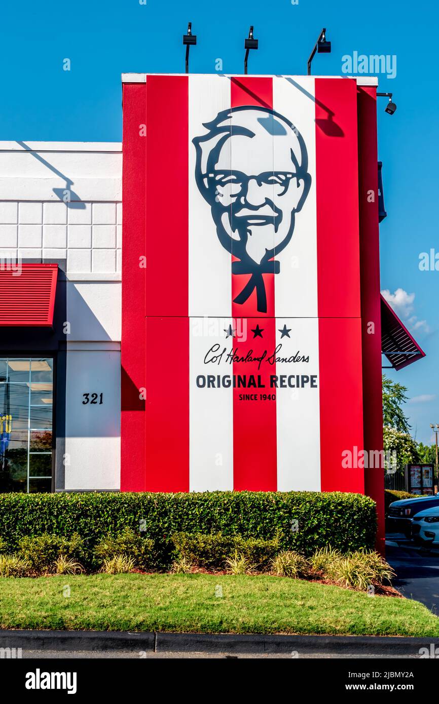 Die Außenfassade von KFC und das Logo von KFC an einem sonnigen Tag mit klarem blauen Himmel, Gras und Sträuchern in South Charlotte, North Carolina. Stockfoto