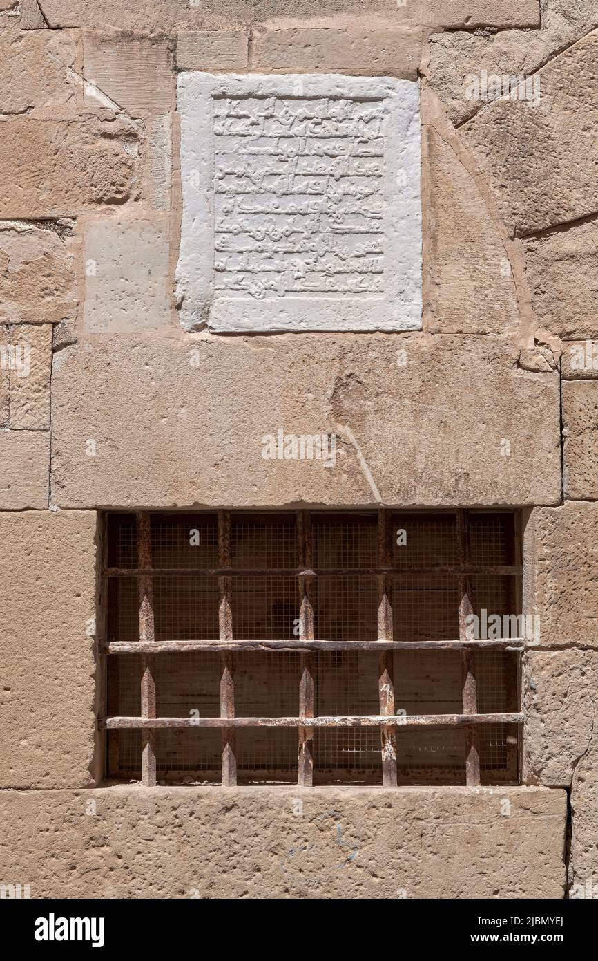 Arabische Inschrift auf einem weißen Stein über dem Fenster an der Fassade der Kathedrale in Path of the Chaplains, Tortosa, Tarragona, Spanien geprägt. Stockfoto