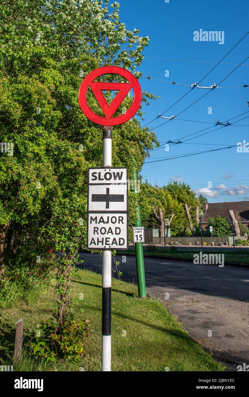 Vintage-Straßenschild, Metall mit schwarz-weißer Aufschrift und einem roten Dreieck und Kreis oben. Stockfoto