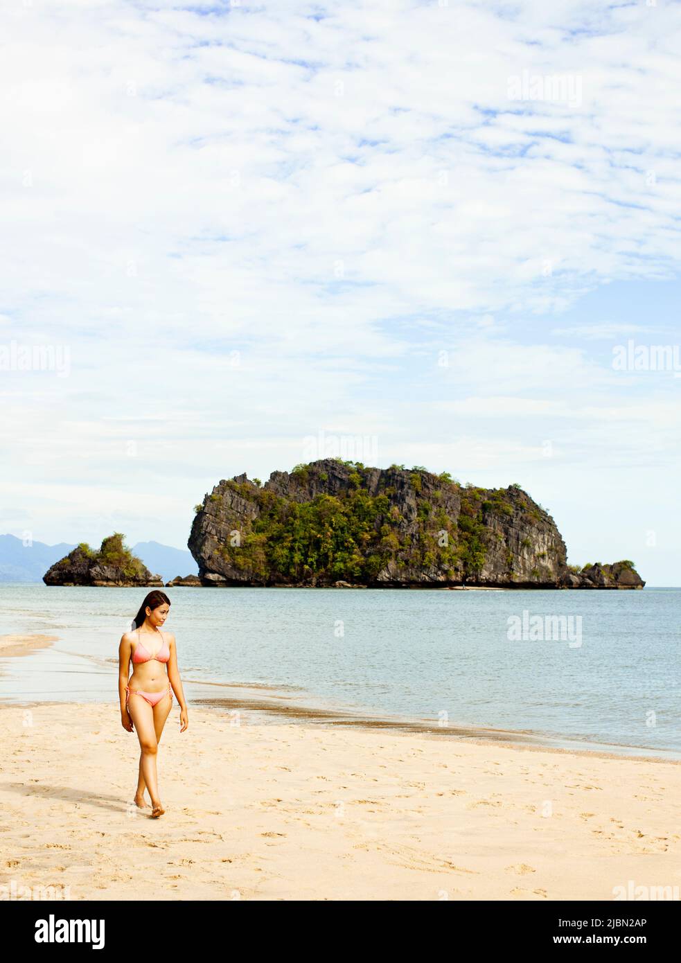 Eine junge malaysische Frau geht auf einer Sandbank in der Tanjung Rhu Cove spazieren. Langkawi, Malaysia. Stockfoto