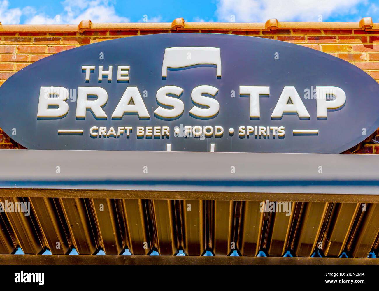 Charlotte, NC/USA - 14. Mai 2019: Horizontaler mittlerer Nahaufnahme von "The Brass Tap"-Bierbar und Grill mit Marke und Logo auf ovalem Schild. Stockfoto
