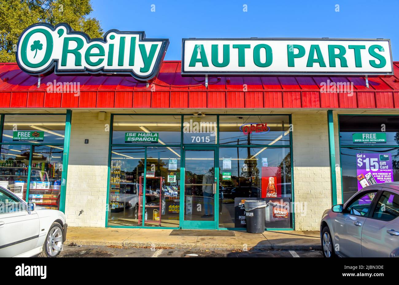 Die Außenfassade des O'Reilly Auto Parts Stores sowie die Logos in Grün und Weiß auf einem roten, gerippten Dach über einer Schaufensterfront aus Glas. Stockfoto
