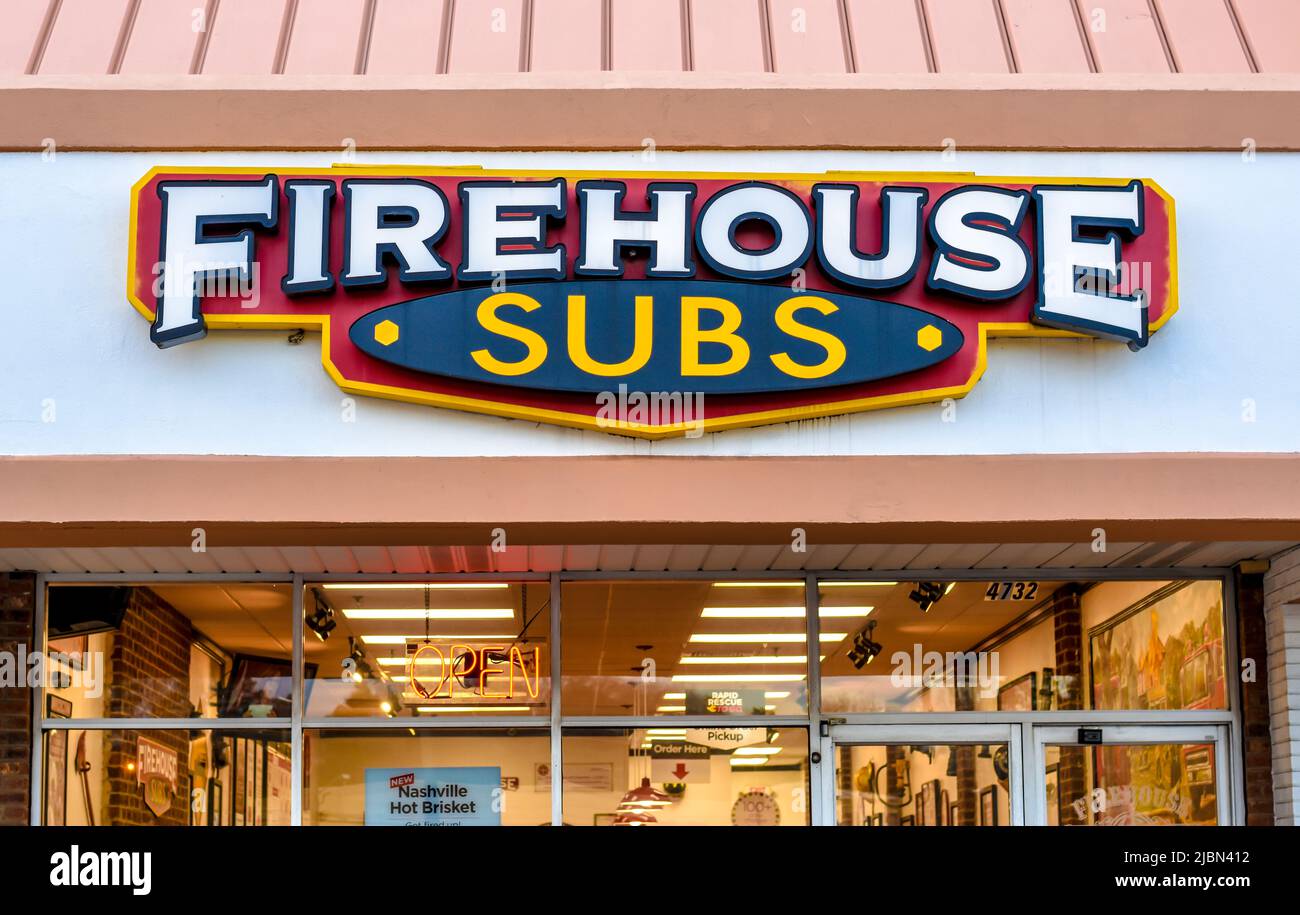 Firehouse Subs Außenfassade Marke und Logo Beschilderung über Glasfenstern und Türen mit beleuchteten Innenraum zeigt erste-Hilfe-Ausrüstung Dekor. Stockfoto