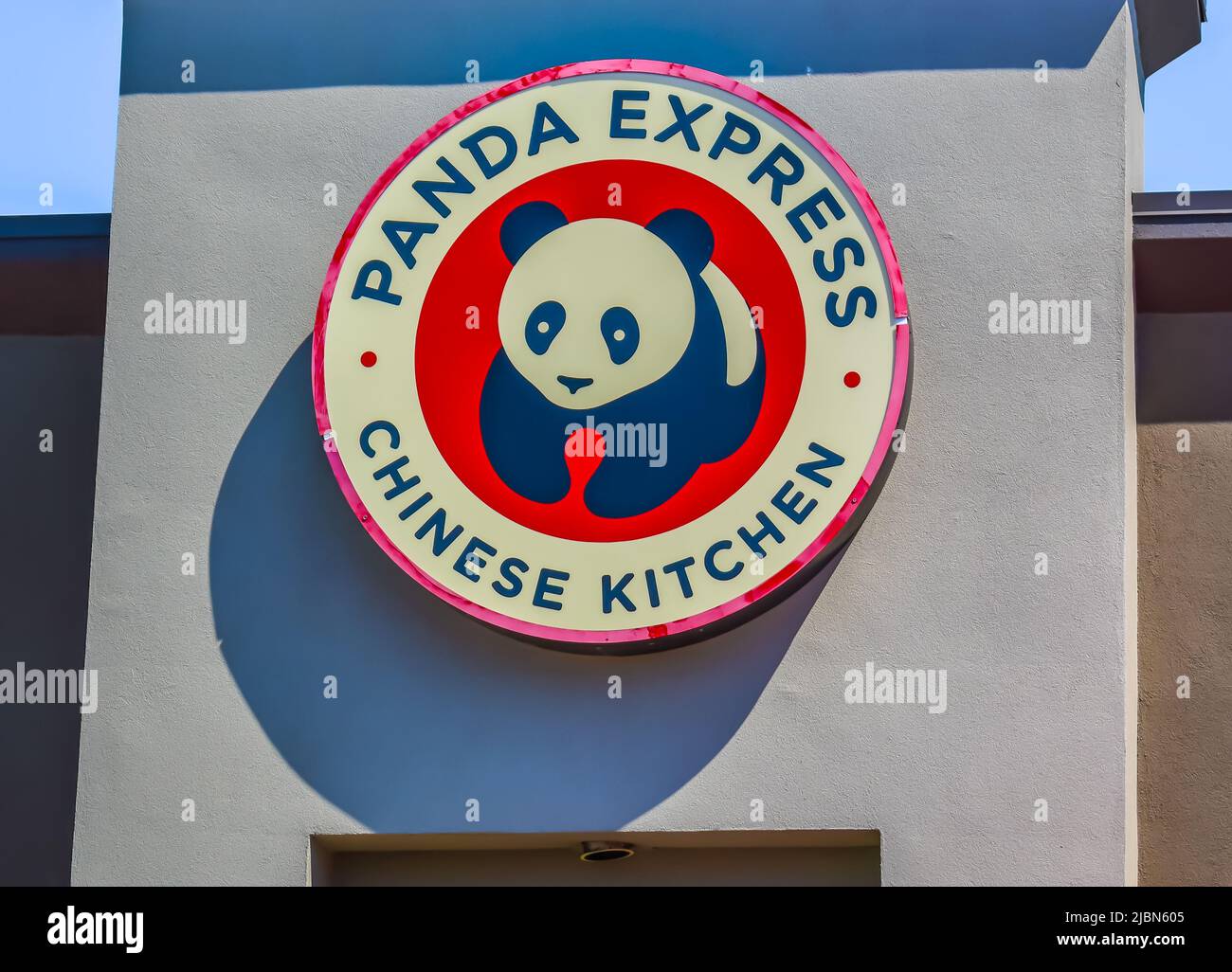 Panda Express Chinese Kitchen hat eine kreisförmige Außenfassade mit Marken- und Logo-Schilder in Rot, Schwarz und Weiß bei strahlendem Sonnenschein und Schatten. Stockfoto