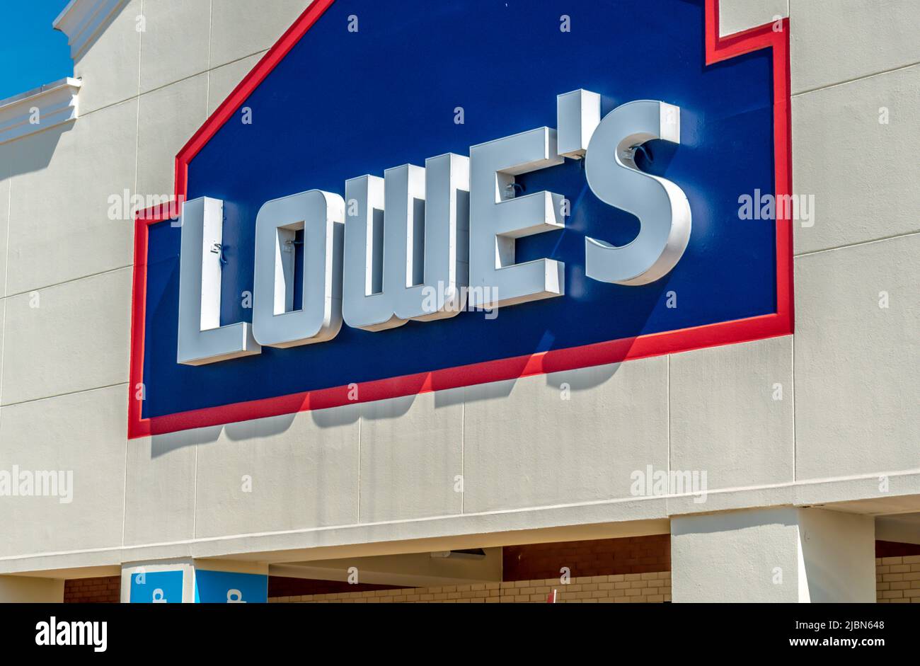 Die Fassadenmarke und das Logo von Lowe's Home Improvement Store in dreidimensionalen, weißen Buchstaben auf dunkelblauem Hintergrund bei sonnigem Tageslicht. Stockfoto