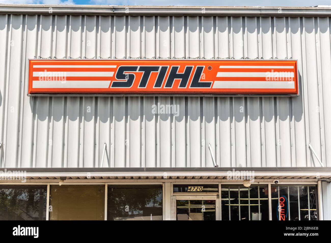 STIHL und Gravely Outdoor Marken- und Logo-Beschilderung in rot und orange auf einer weißen gerippten Metallfassade in hellem Sonnenlicht in South Charlotte, NC. Stockfoto