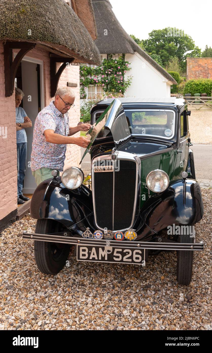 Hampshire, England, Großbritannien. Nach einer Motorprüfung die Motorhaube herunterfahren, bevor Sie in diesem zweifarbigen Morris-Eight-Oldtimer fahren. Stockfoto
