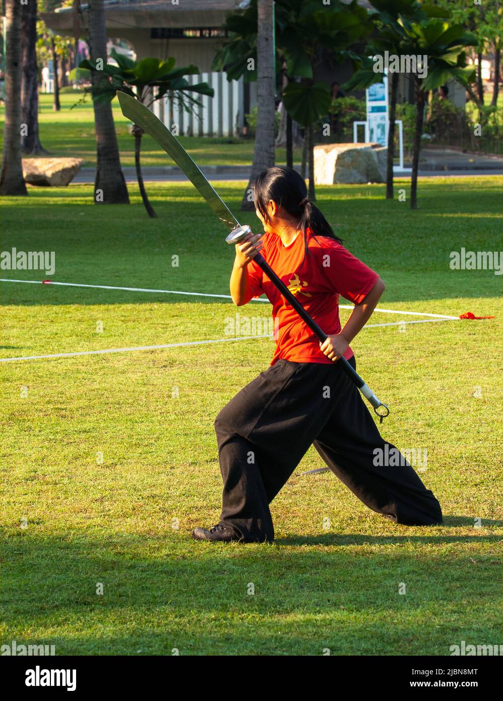 Die junge Thailänderin Tai Chi trainiert mit einem Schwert im Lumpini Park, Bangkok, Thailand Stockfoto