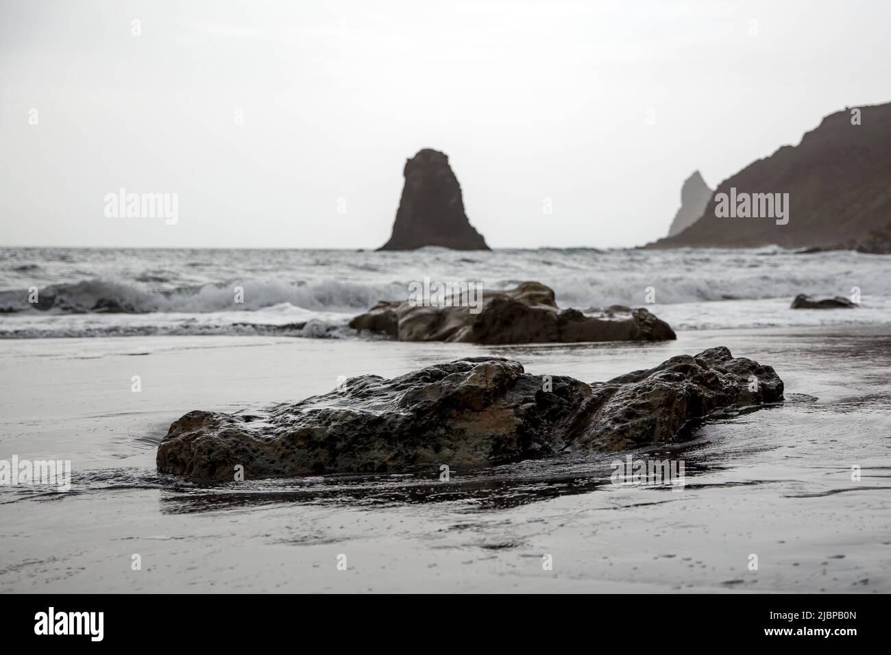 Schwarze vulkanische Felsen an der Meeresküste. Stockfoto