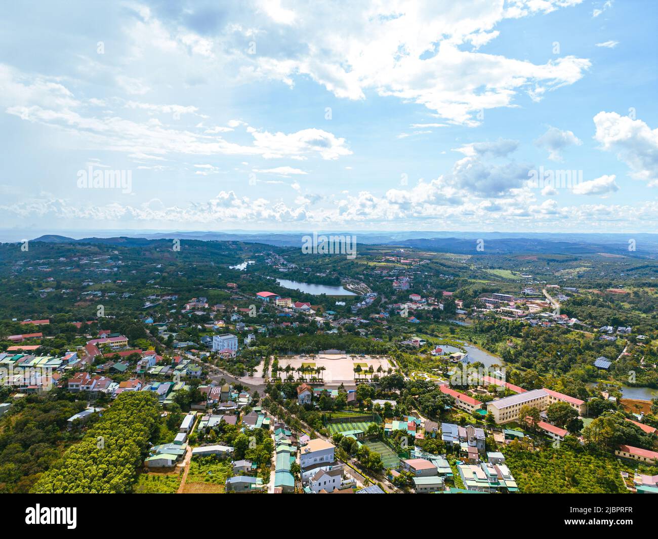 Luftaufnahme der National Route 14 in Kien Duc Stadt, DAC Nong Provinz, Vietnam mit hügeliger Landschaft und spärlicher Bevölkerung rund um die Straßen. Reisen und Stockfoto