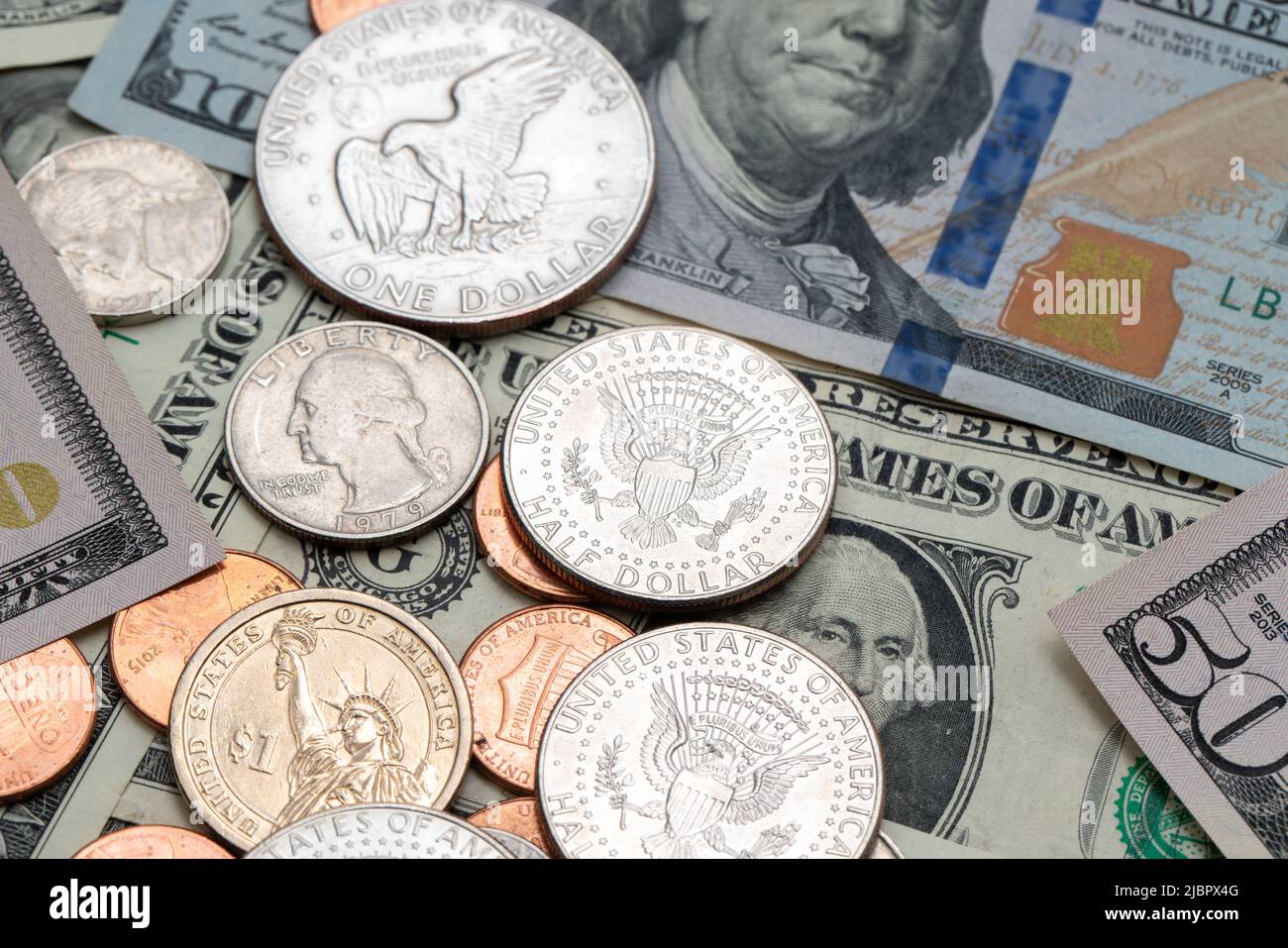 US-Dollar-Münzen auf Banknoten. Eine halbe Dollar-Münze auf einem 100-Dollar-Schein. Banknote der US-Notenbank Stockfoto