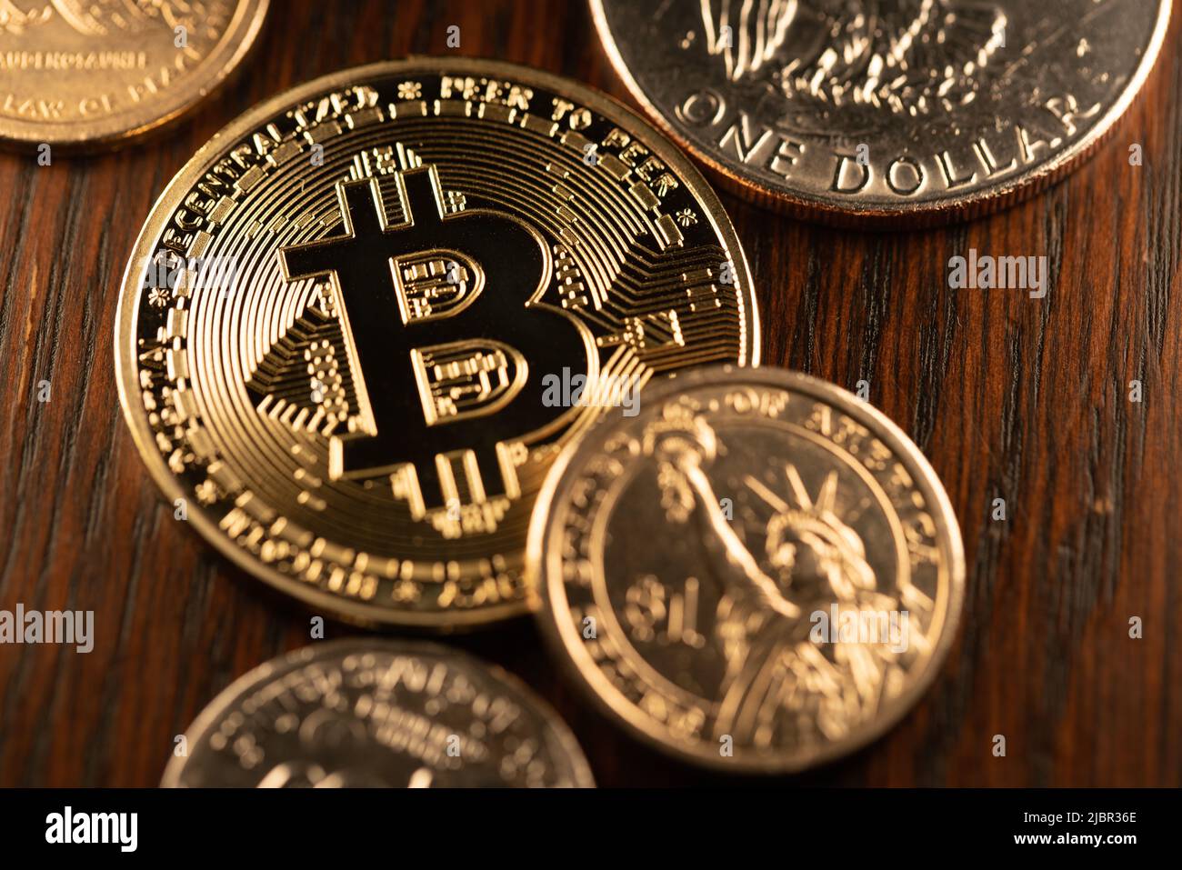 Dollarmünzen, die einen Goldbitcoin umgeben. Digitale Krypto-Währung mit US-Dollar-Münzen. Handel und Preis von Crypto in USD Stockfoto